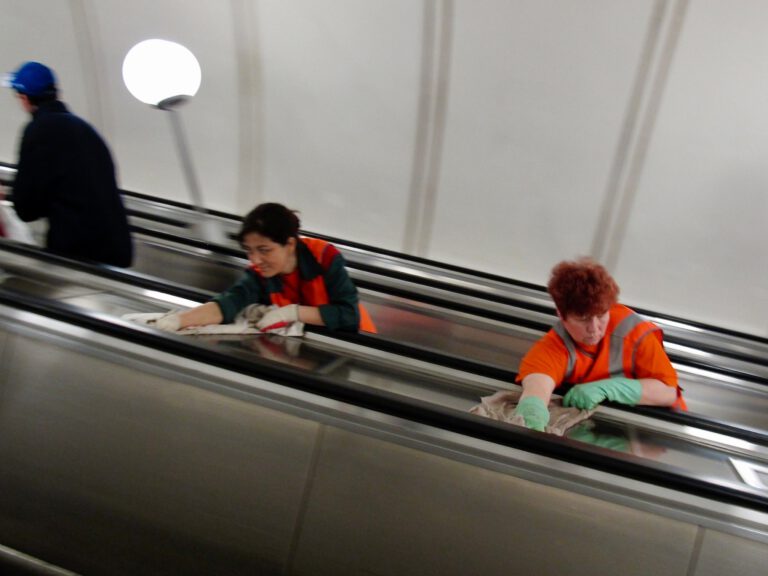 Zwei Mitarbeiterinnen reinigen eine Rolltreppe in einer Metrostation
